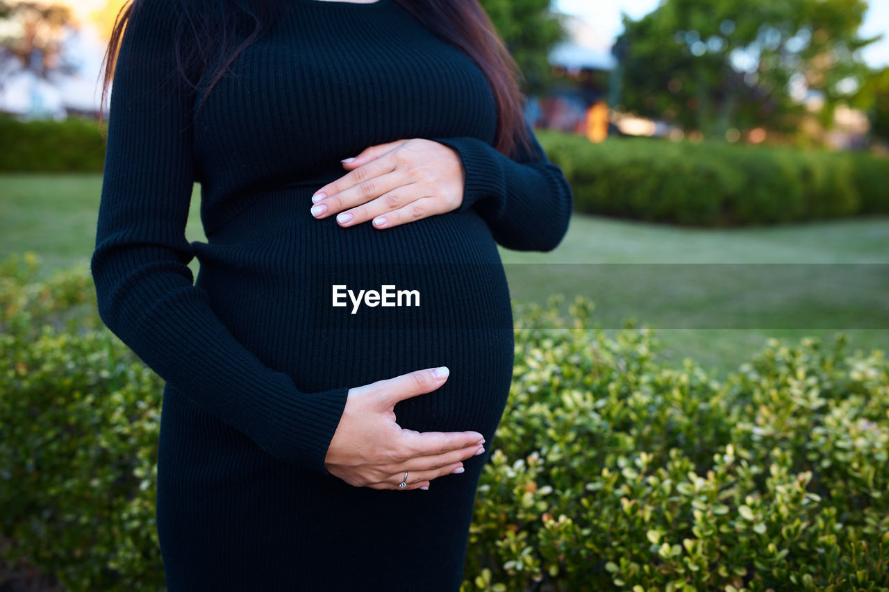 rear view of woman wearing hat standing against plants