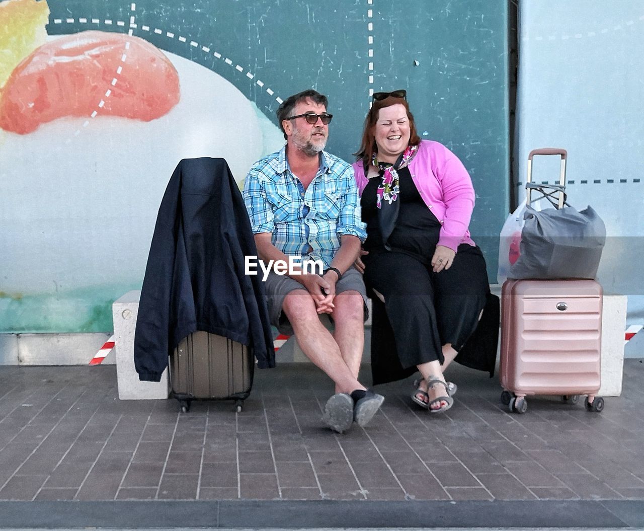 FULL LENGTH PORTRAIT OF FRIENDS SITTING ON WALL