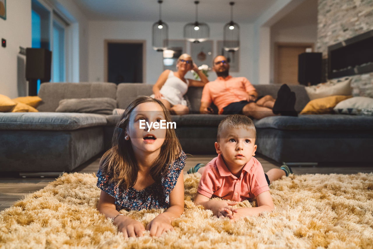 high angle view of mother and daughter sitting on sofa at home