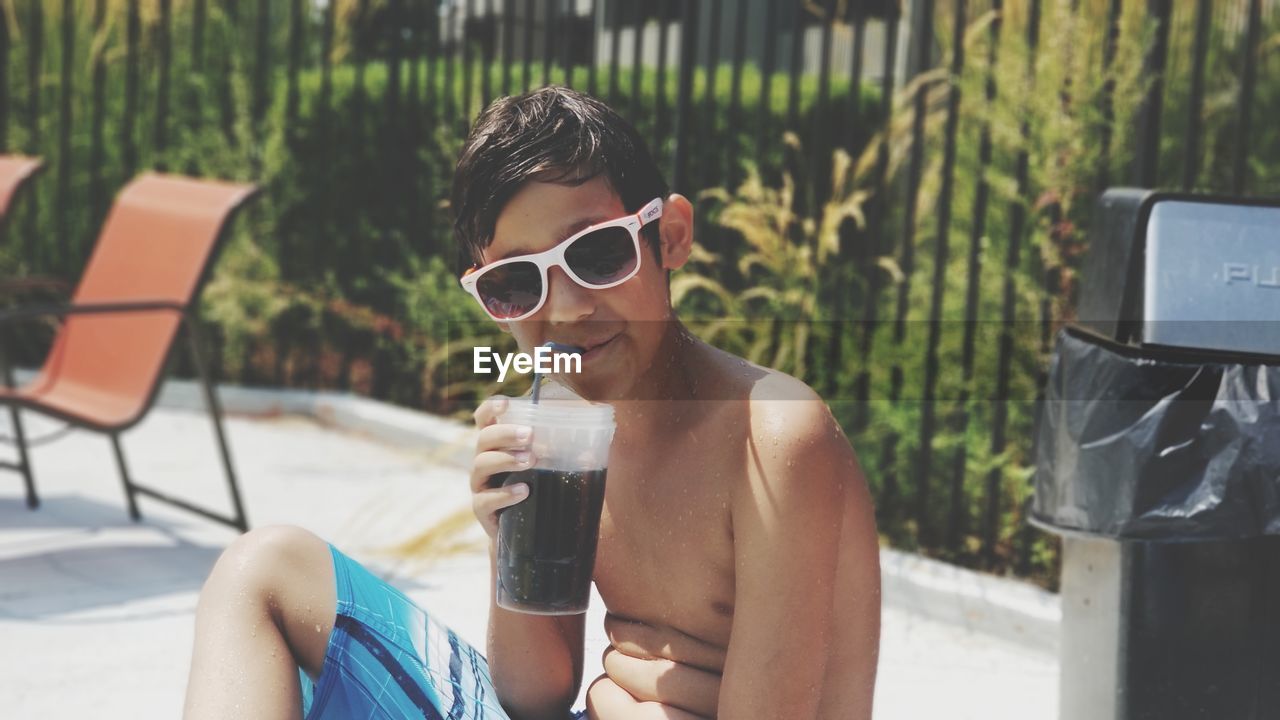 YOUNG WOMAN DRINKING WATER IN POOL