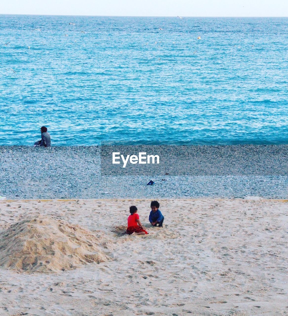 REAR VIEW OF FRIENDS ON BEACH