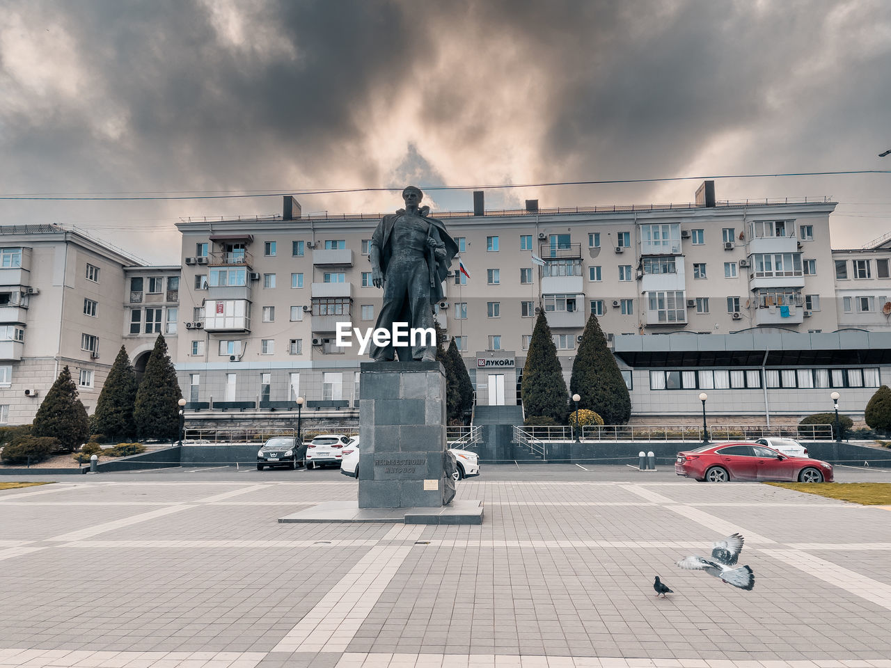 STATUE AGAINST CITY STREET AGAINST SKY