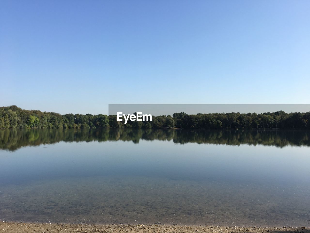 Scenic view of lake against clear blue sky