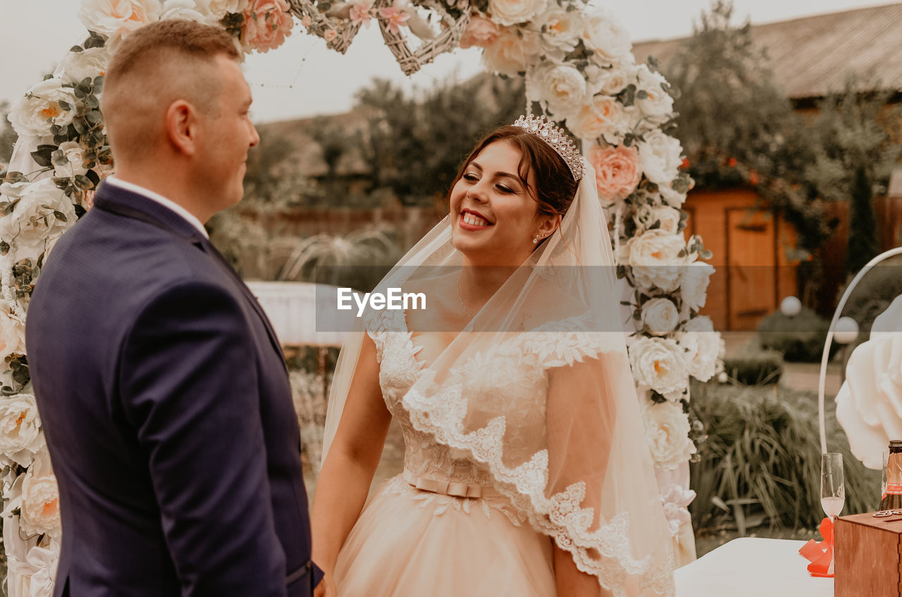 portrait of bride and bridegroom holding hands in traditional clothing