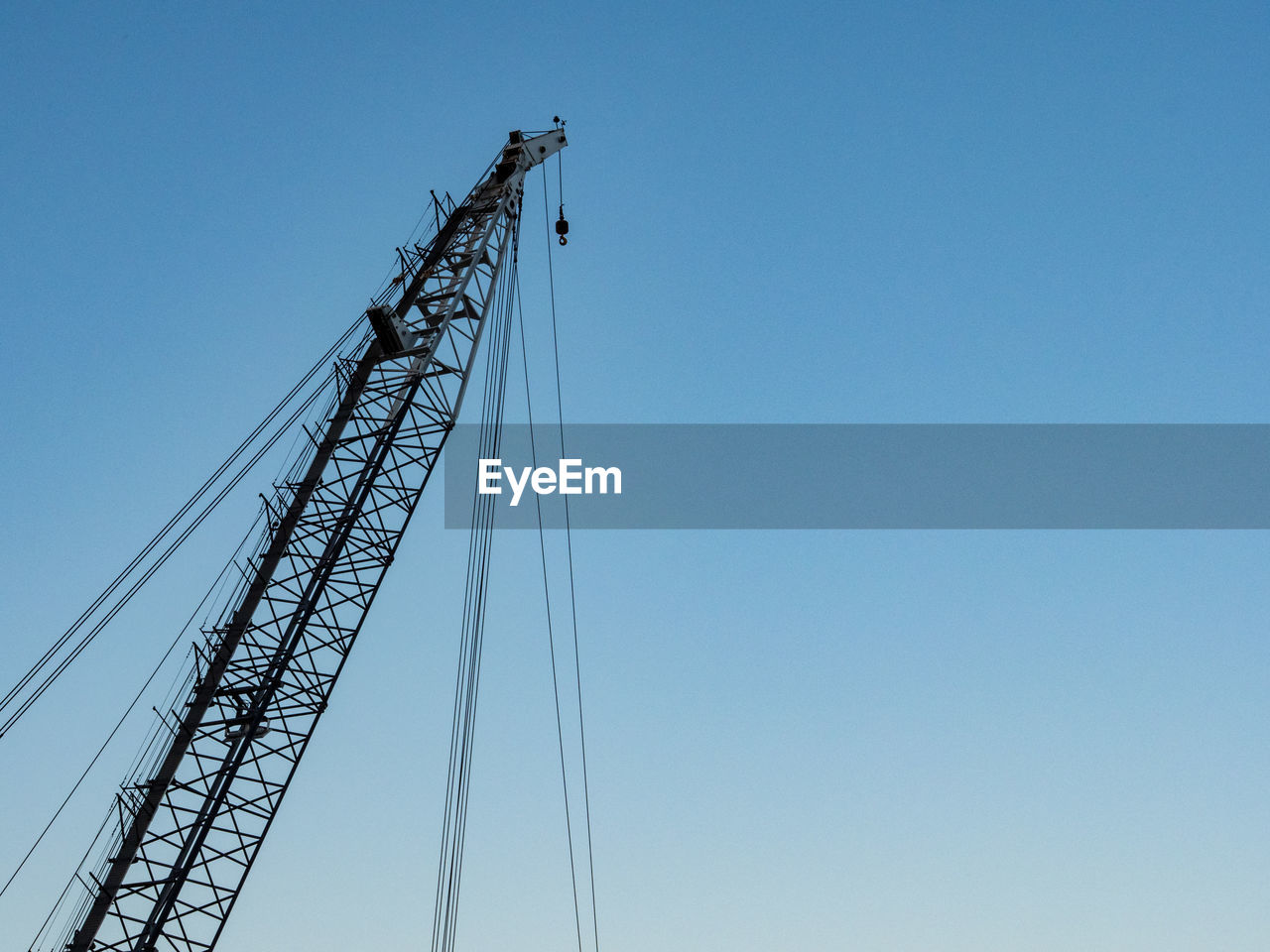 LOW ANGLE VIEW OF CRANES AGAINST CLEAR SKY