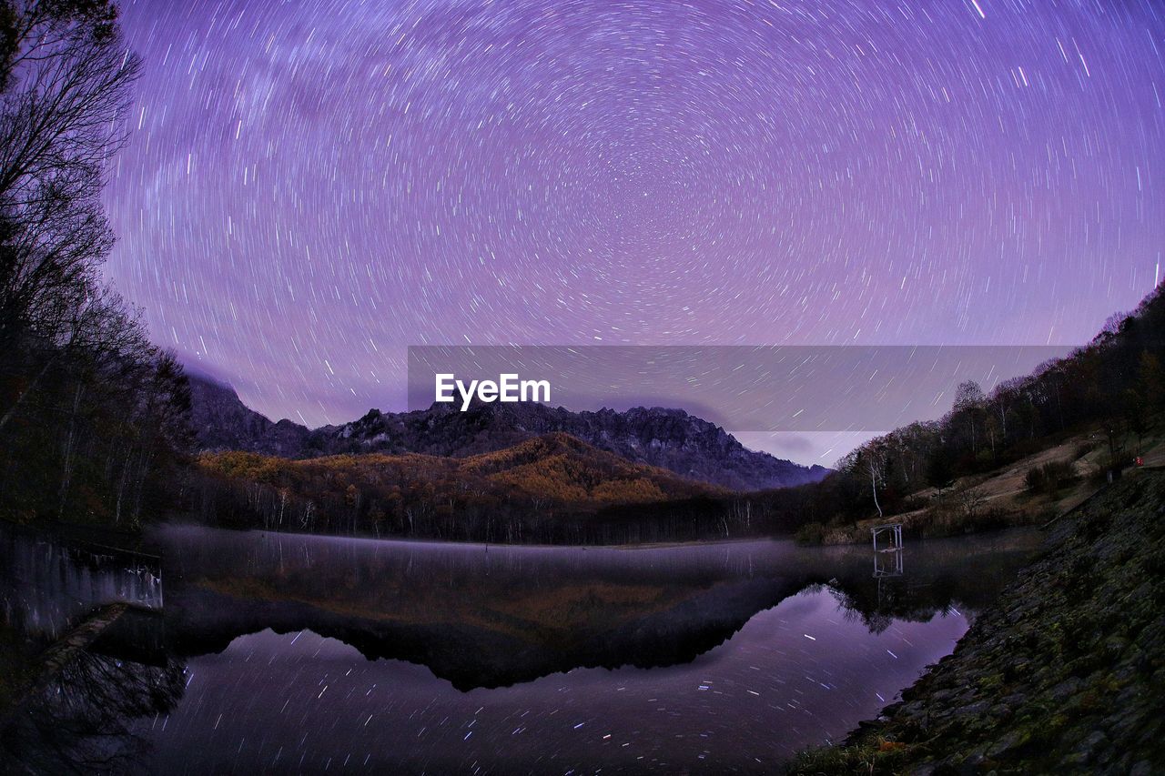 SCENIC VIEW OF LAKE AGAINST MOUNTAIN AT NIGHT