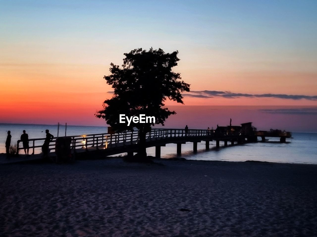 sky, sunset, water, sea, horizon, dusk, beach, nature, beauty in nature, evening, scenics - nature, land, pier, silhouette, tranquility, ocean, tree, architecture, horizon over water, tranquil scene, shore, coast, travel destinations, cloud, afterglow, idyllic, built structure, orange color, holiday, reflection, outdoors, plant, vacation, trip, sunlight, tourism, travel, sun, seascape, city