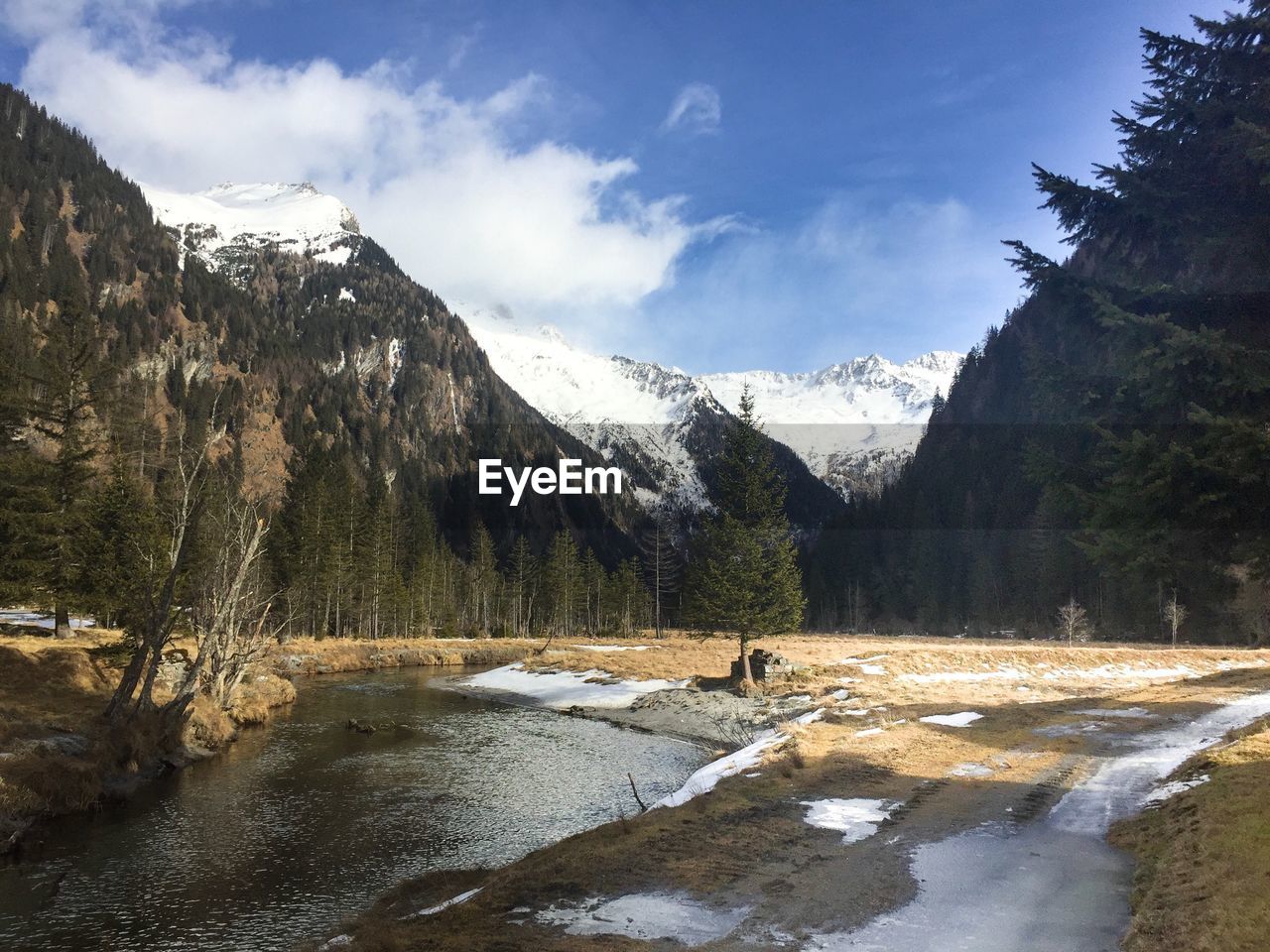 Scenic view of lake by mountains against sky