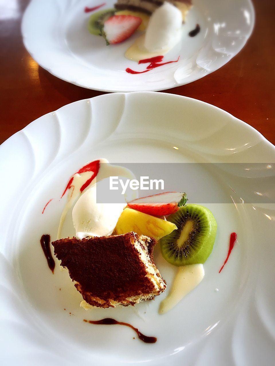 Directly above shot of tiramisu cake and fruits on plate