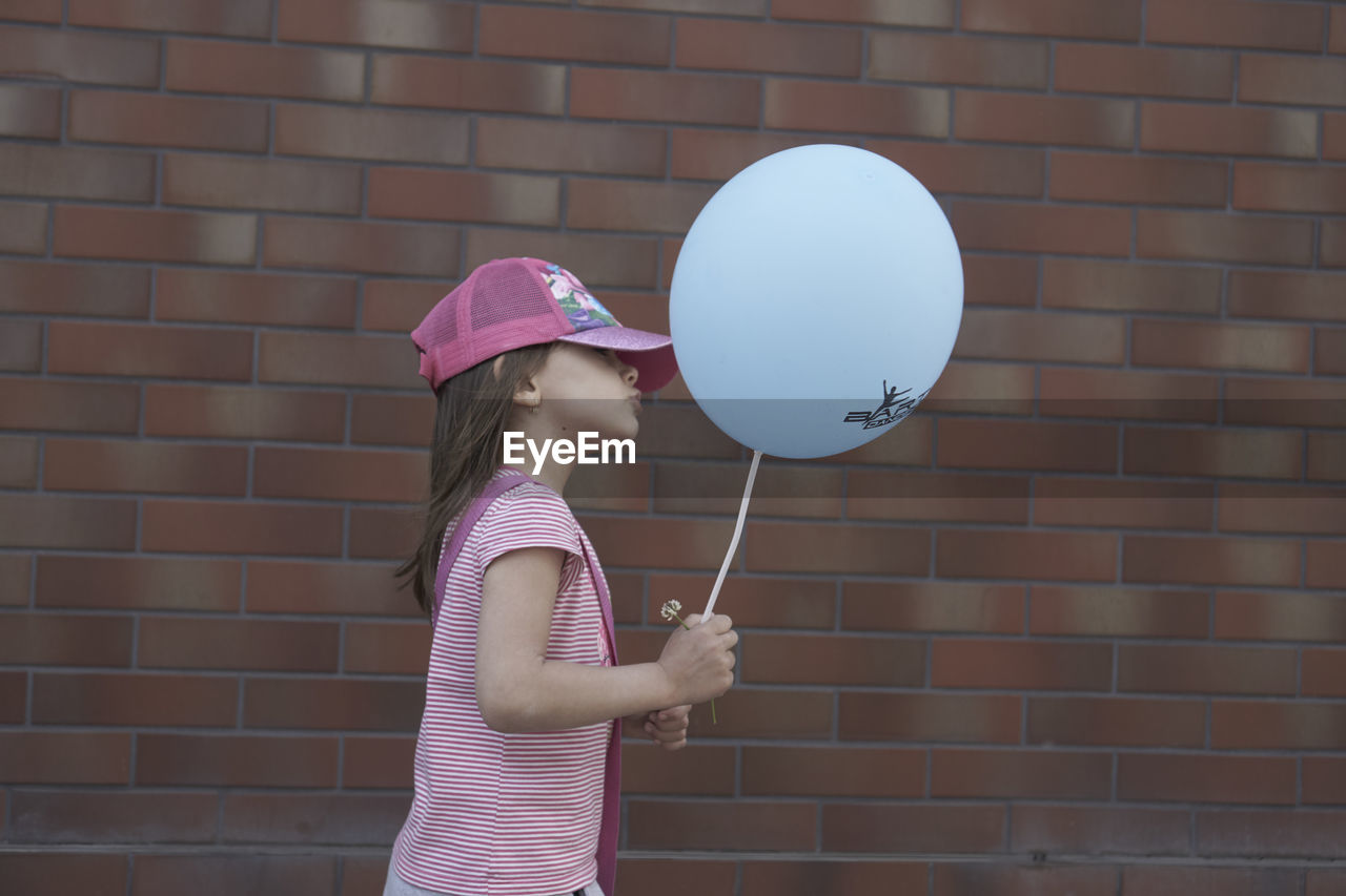 SIDE VIEW OF GIRL HOLDING UMBRELLA