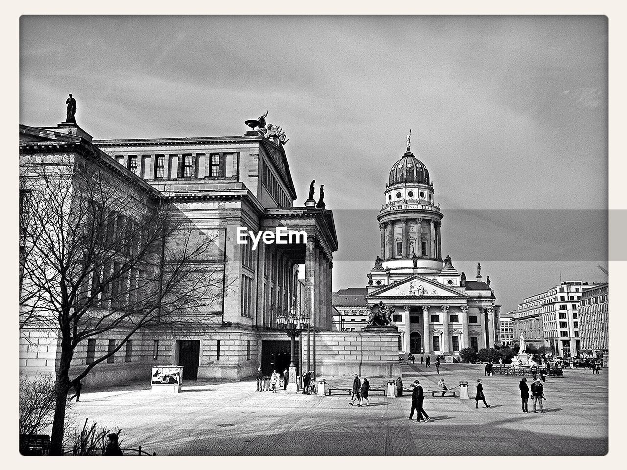 People walking on street near historic building and cathedral in city