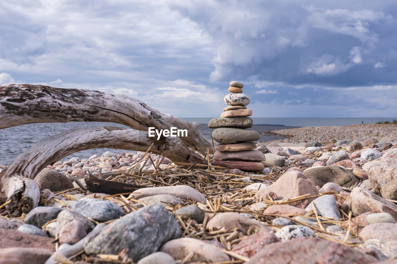 Stack of stones on rock against sky