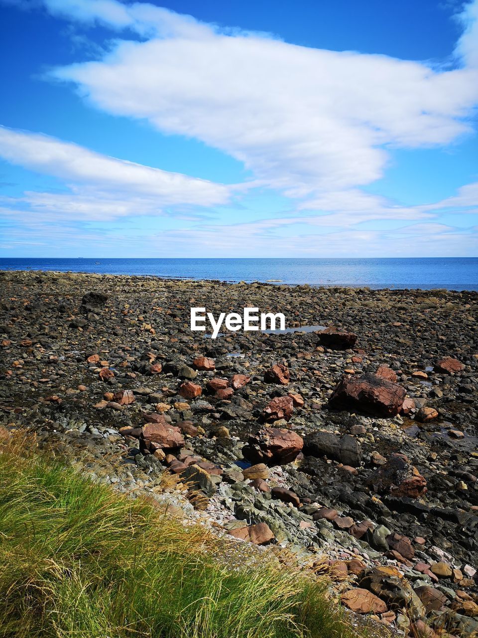 ROCKS ON SHORE AGAINST SKY