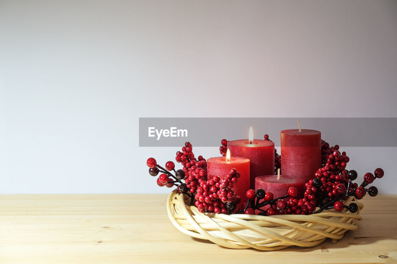 candle, food and drink, food, flame, red, indoors, copy space, burning, lighting, celebration, studio shot, fire, fruit, healthy eating, nature, table, no people, freshness, still life, holiday, decoration, birthday cake, wood, christmas, berry, container, wellbeing, sweet food