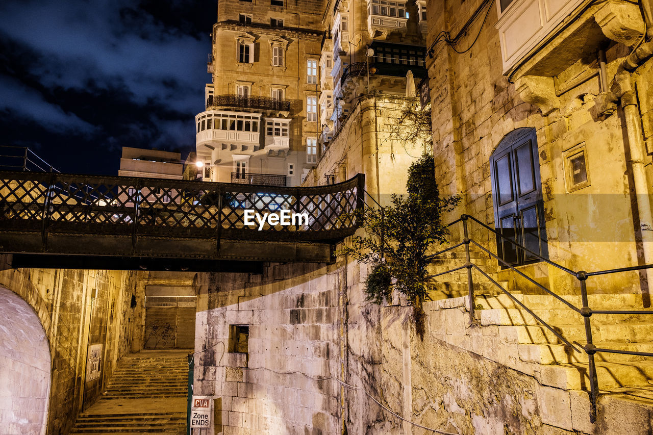 LOW ANGLE VIEW OF ILLUMINATED BUILDING AGAINST SKY