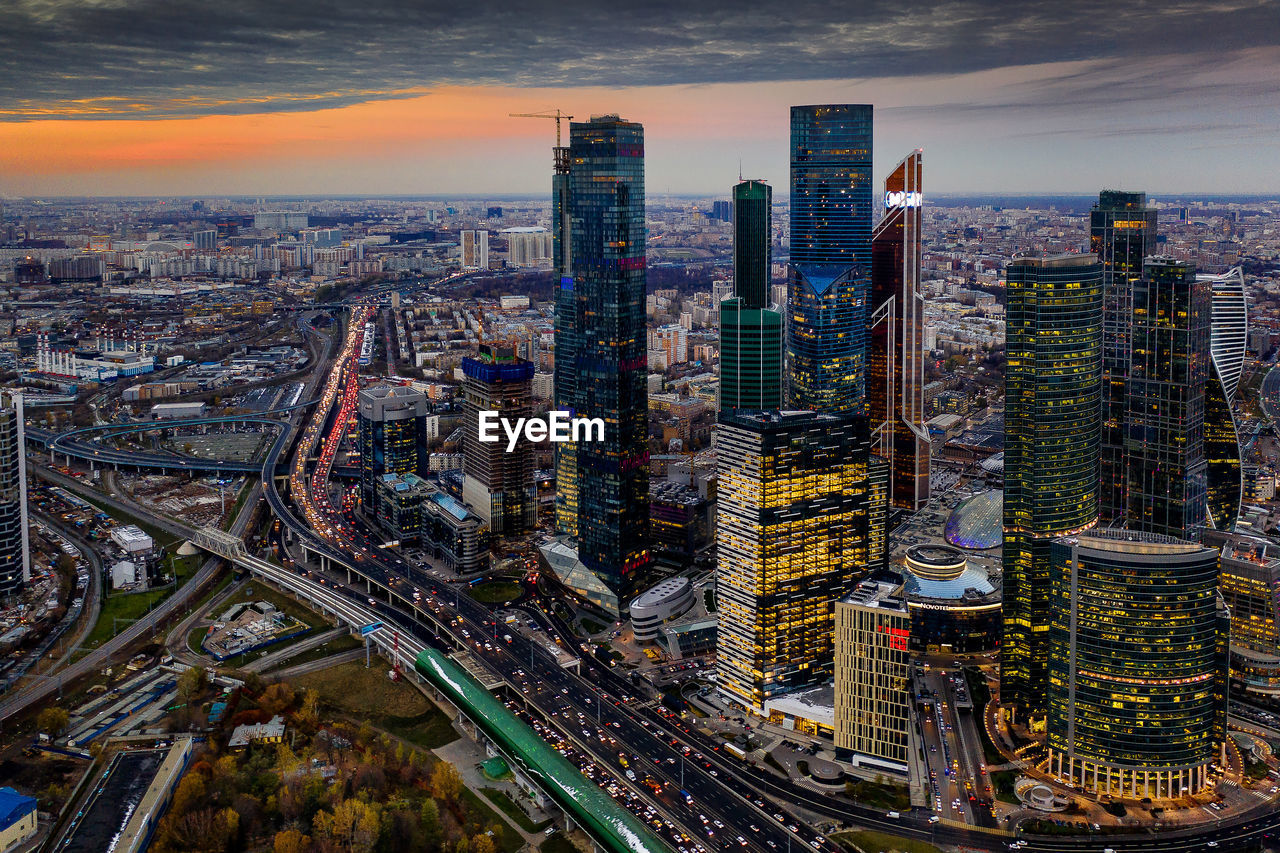 High angle view of illuminated buildings in city at sunset