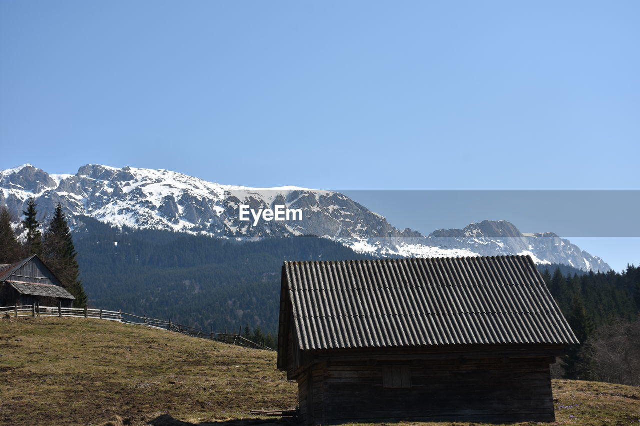 Built structure on snowcapped mountains against clear sky