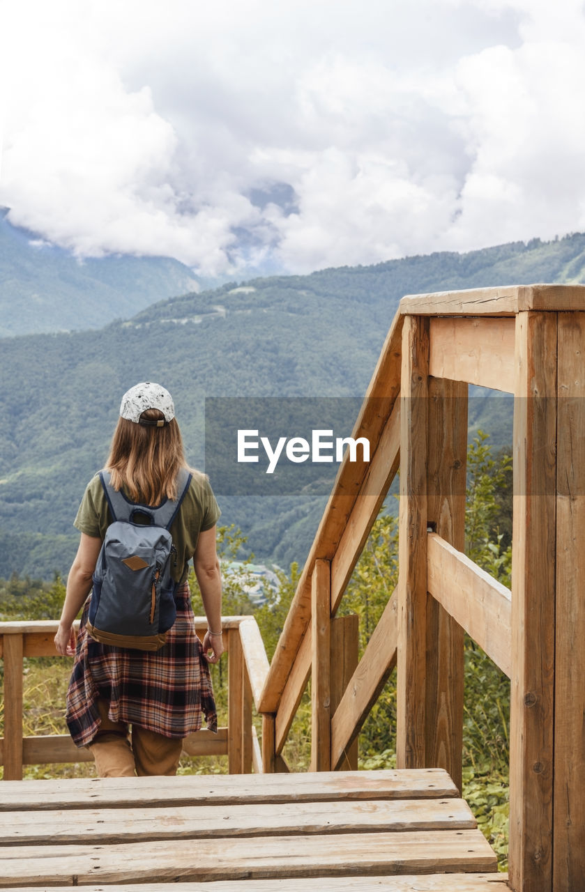 REAR VIEW OF WOMAN LOOKING AT VIEW OF MOUNTAIN