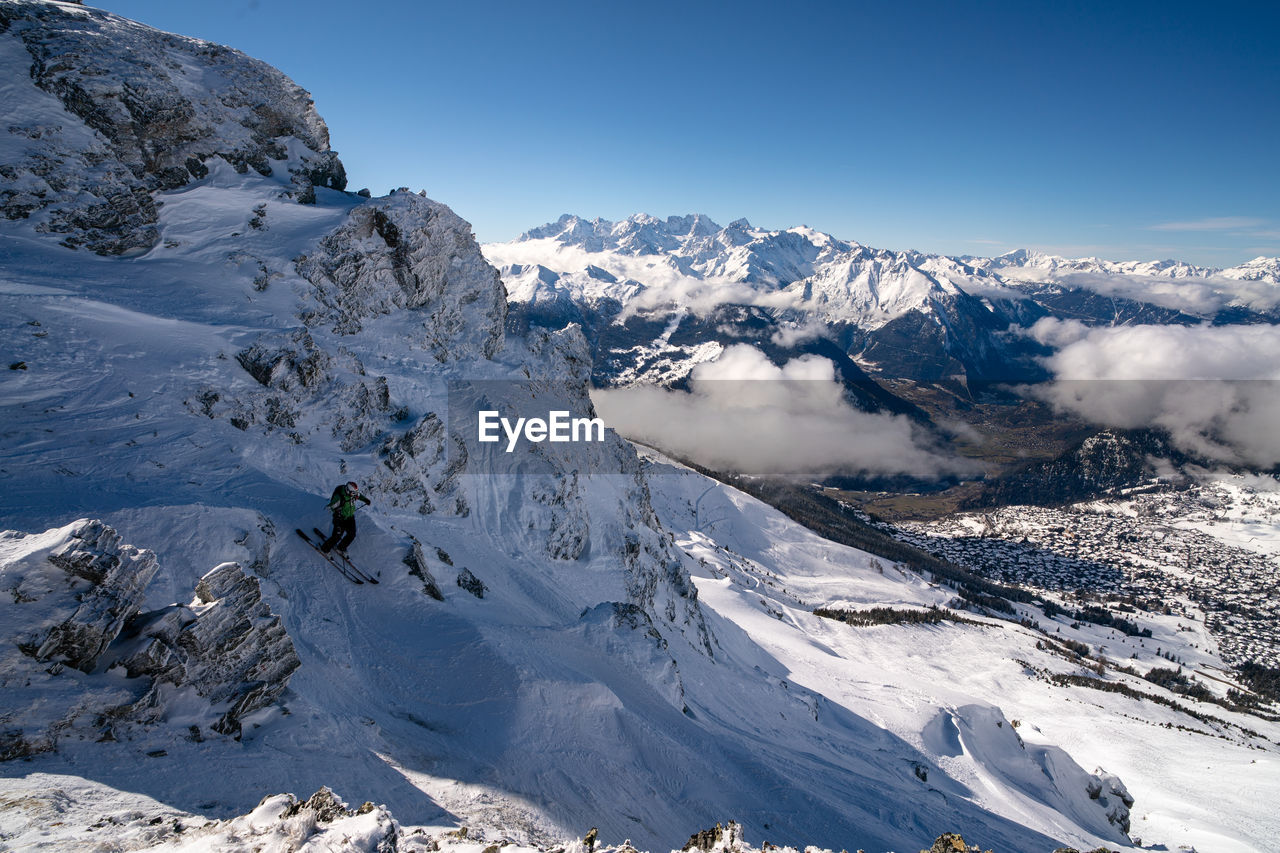 Scenic view of a skier on snowcapped mountains against verbier 