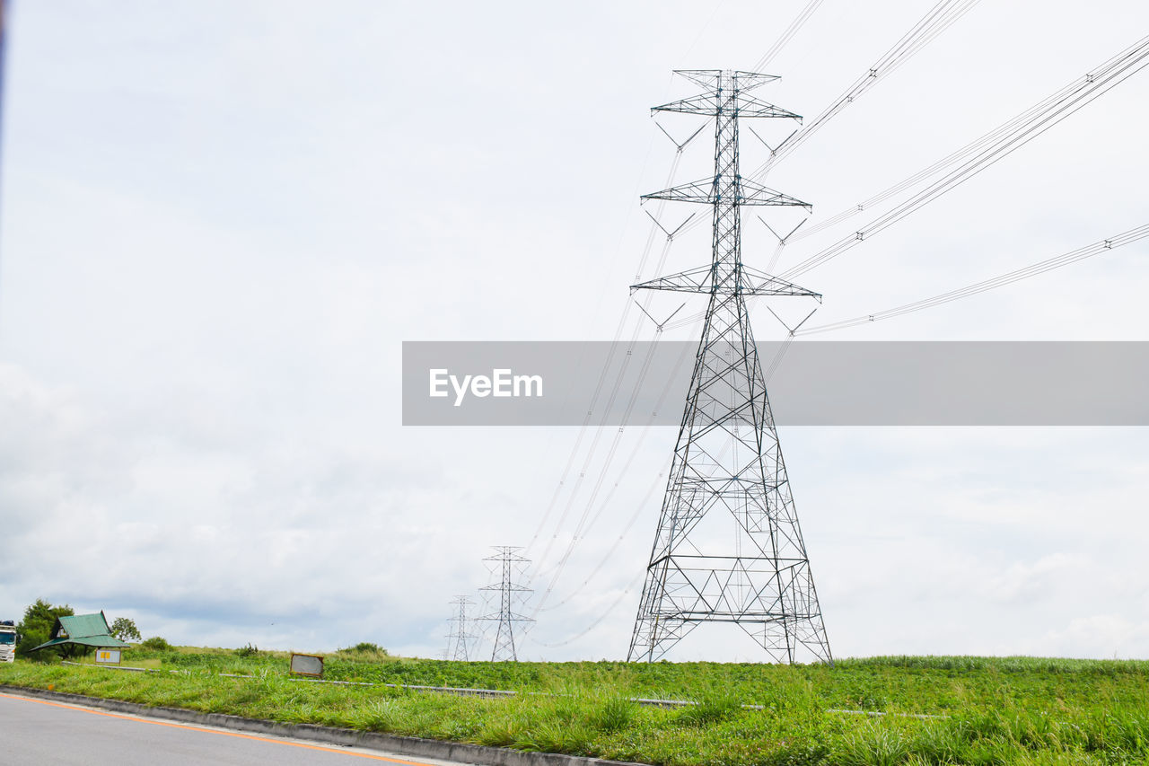 Low angle view of electricity pylon on field against sky