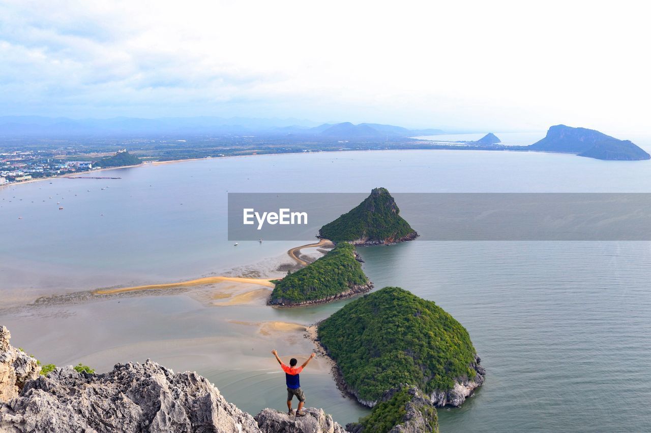 HIGH ANGLE VIEW OF ROCKS ON SHORE AGAINST SKY