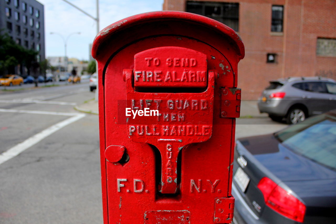 Close-up of text on fire alarm at sidewalk