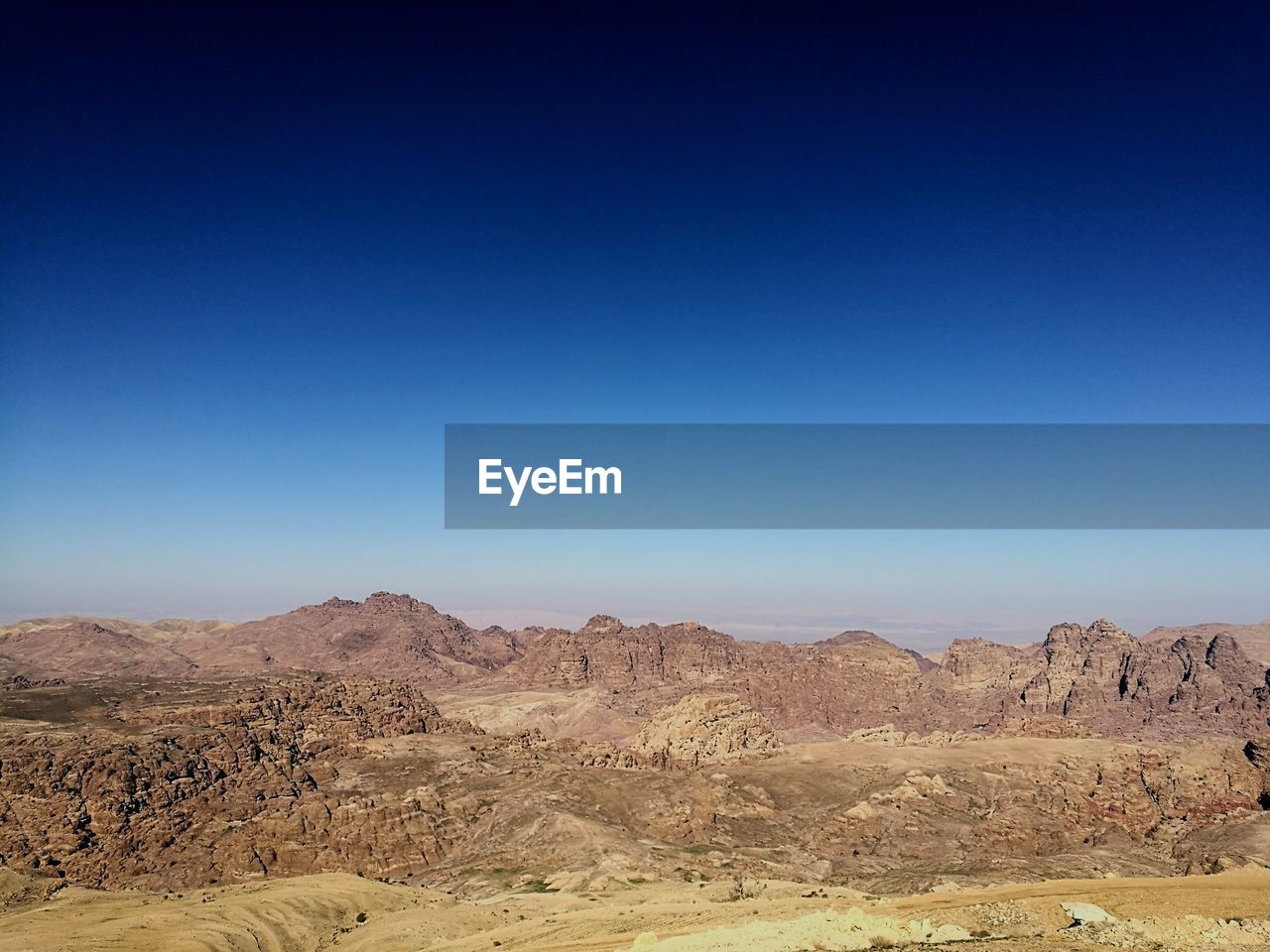 Scenic view of desert against clear blue sky