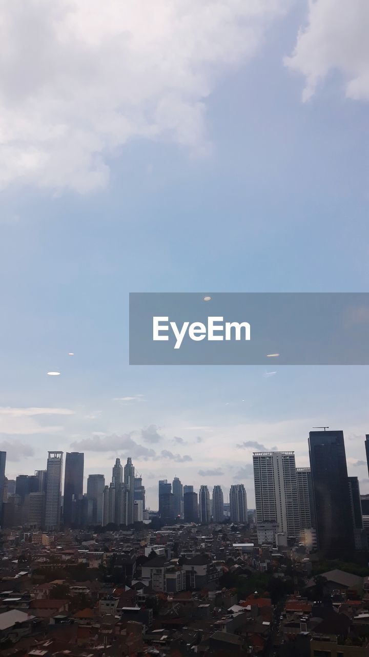 BUILDINGS AGAINST CLOUDY SKY