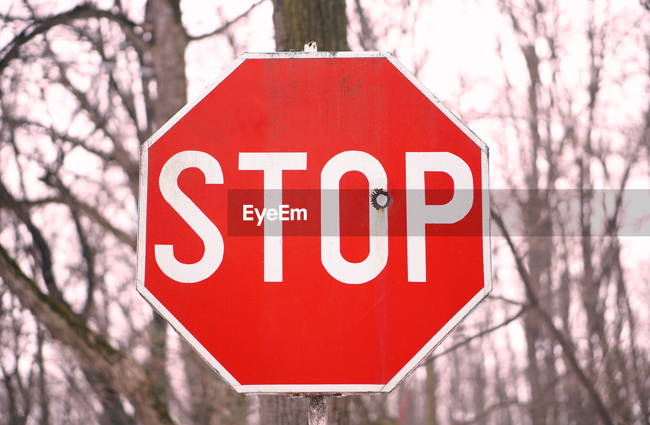 Close-up of road sign against sky