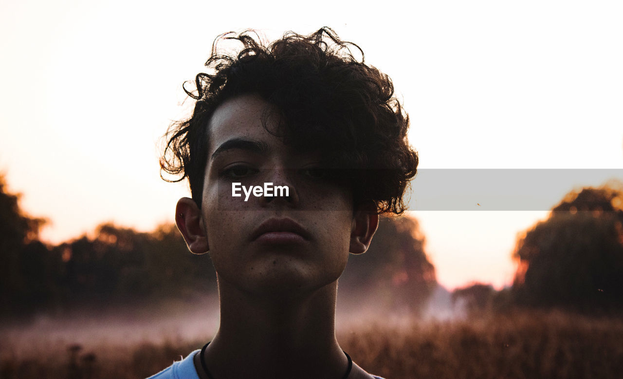 Close-up portrait of young man against clear sky