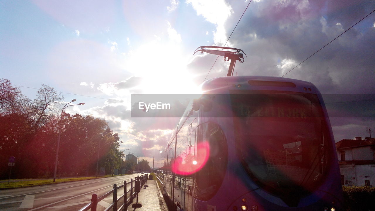 Train on railroad tracks against cloudy sky