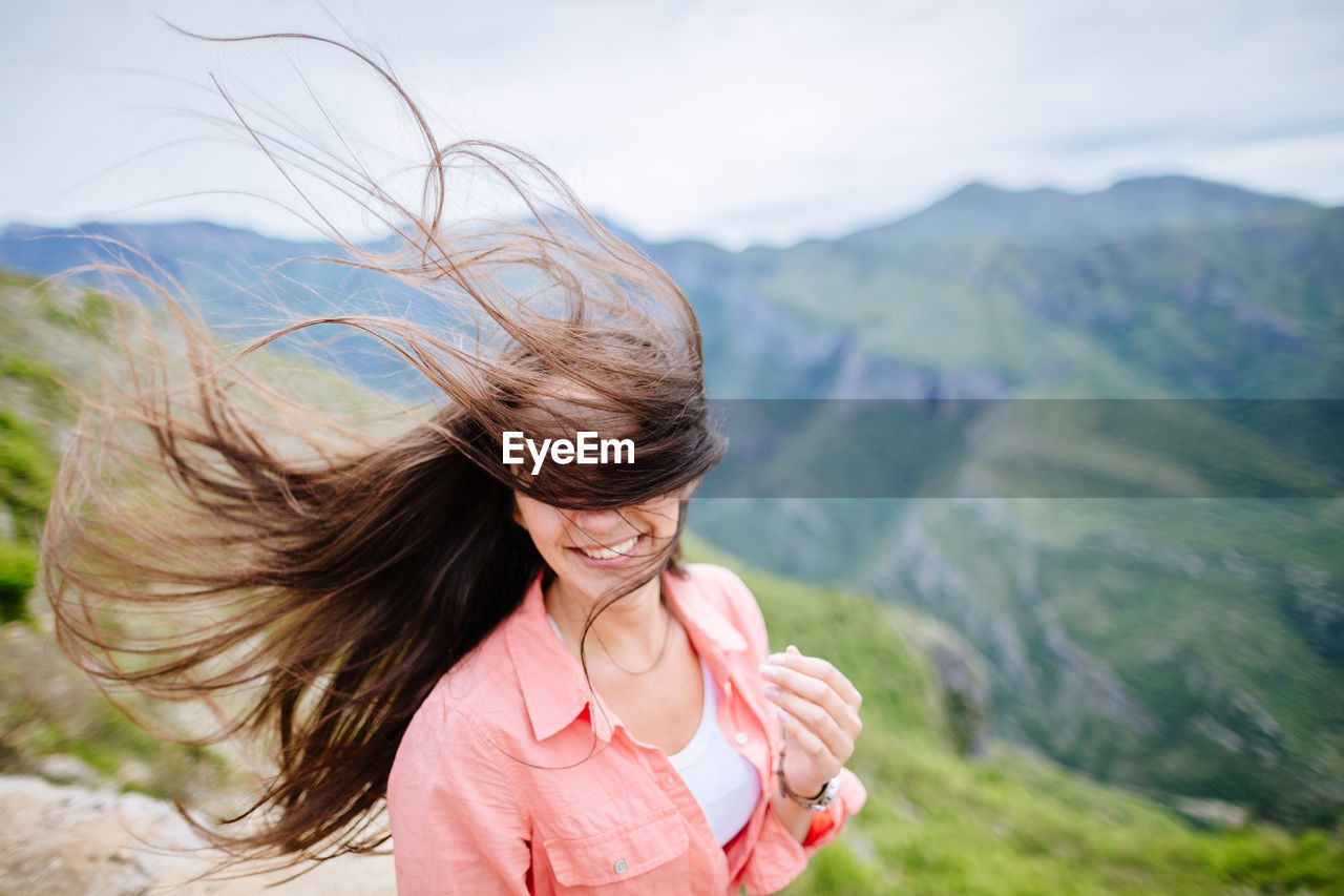 Young woman smiling against mountains