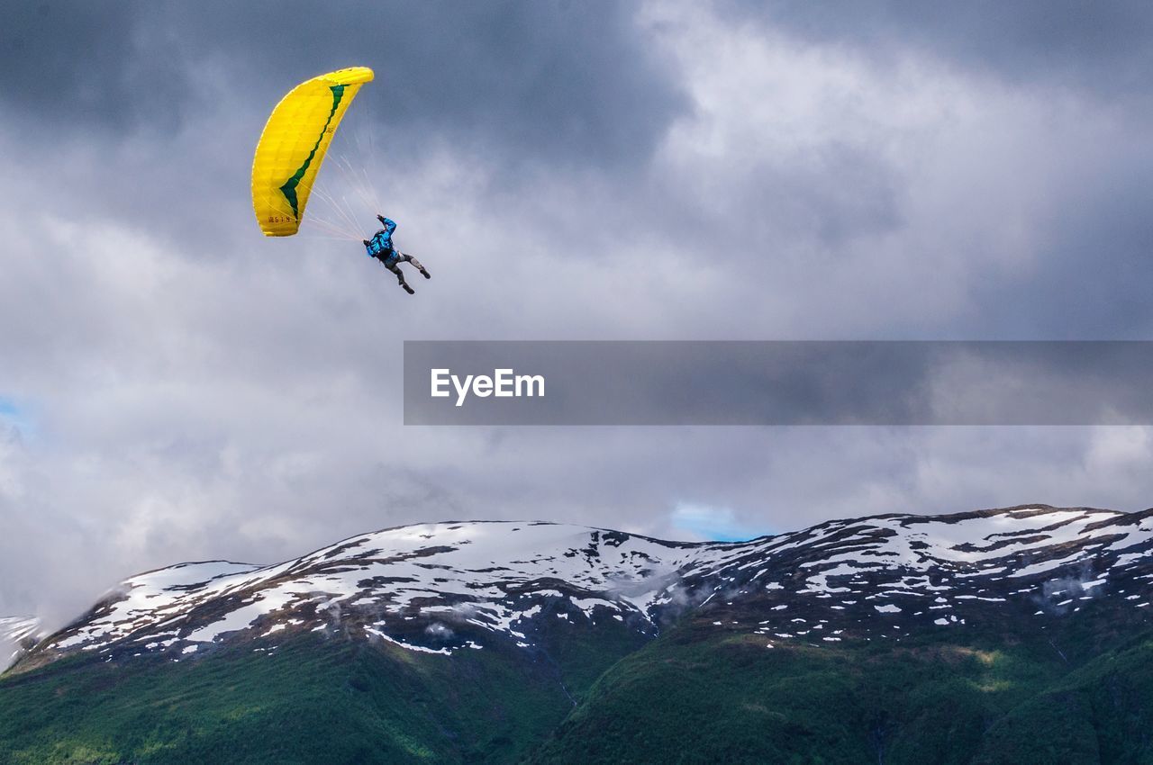 Low angle view of person paragliding against sky