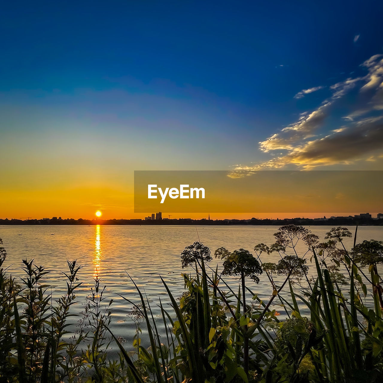 SCENIC VIEW OF LAKE AGAINST ORANGE SKY