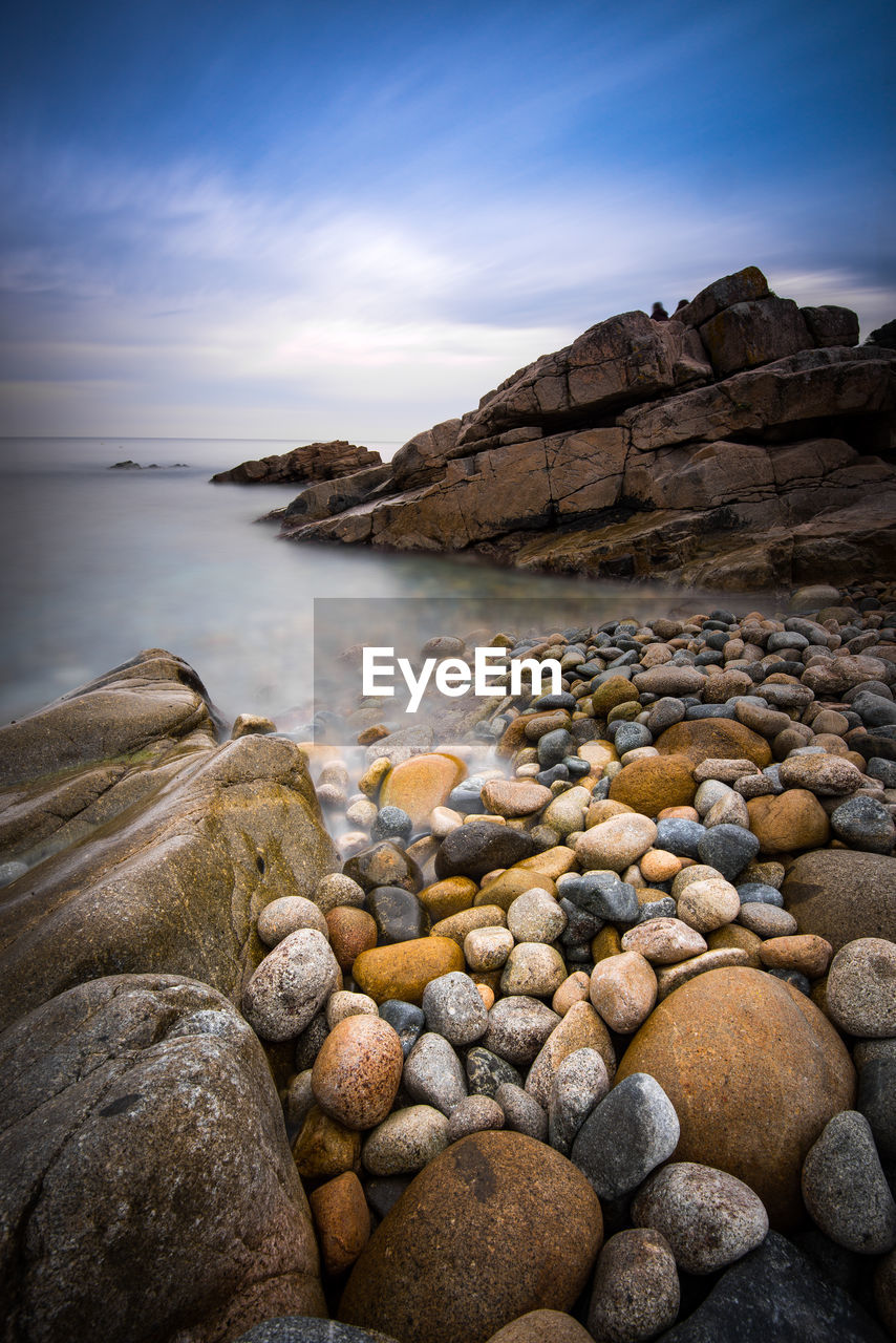 Rocks in sea against sky