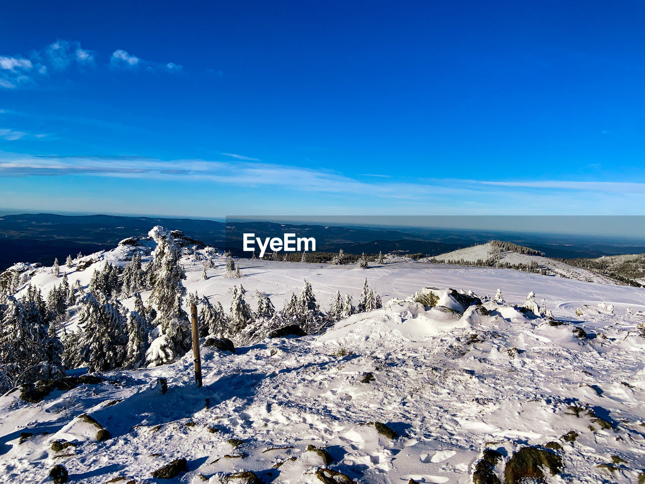 Scenic view of snowcapped landscape against blue sky