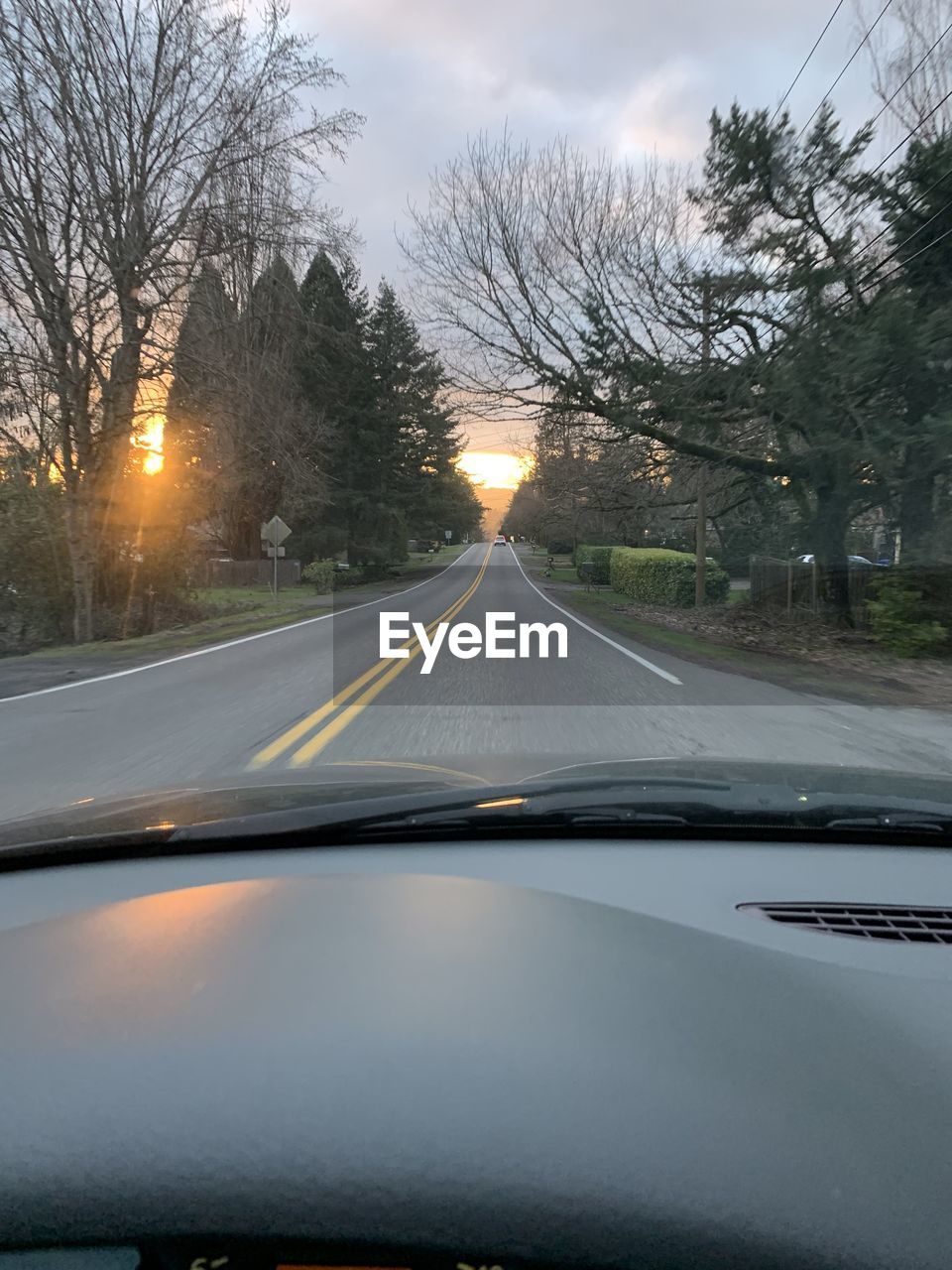 ROAD SEEN THROUGH WINDSHIELD OF CAR