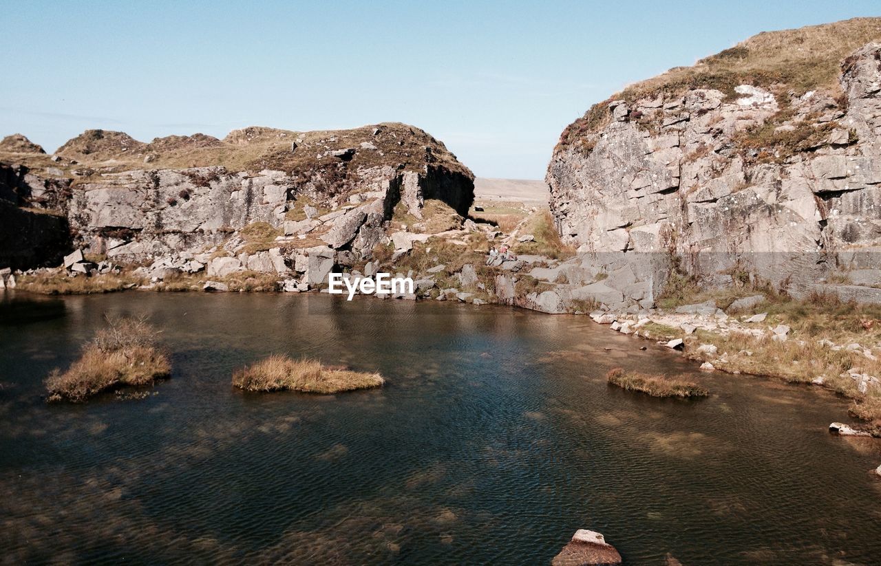 River by rock formations against sky at dartmoor national park