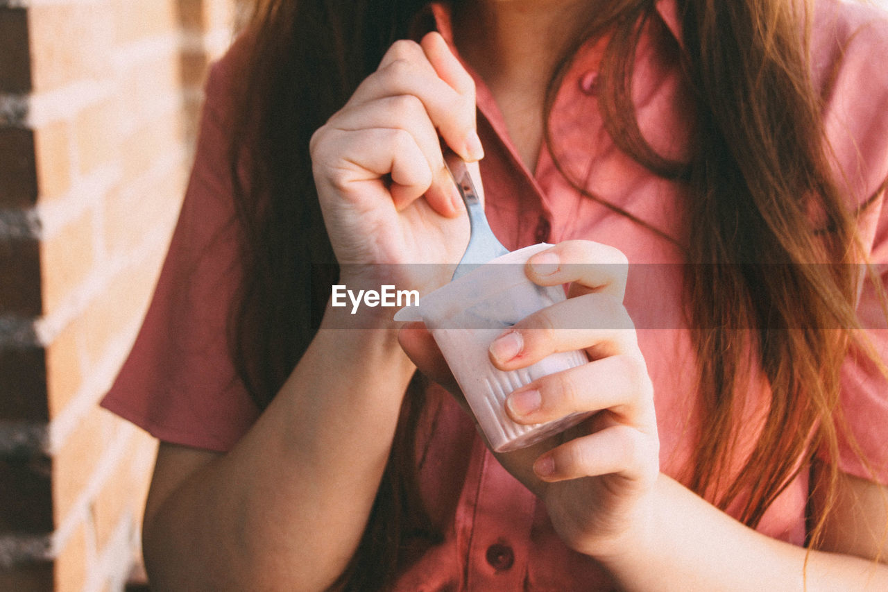 Close-up of woman eating yogurt