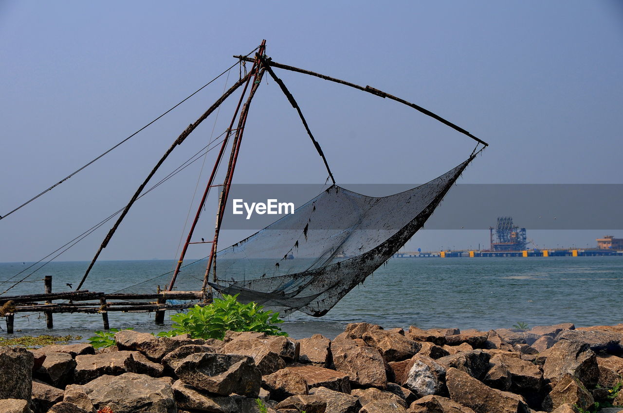 View of fishing net on beach against sky