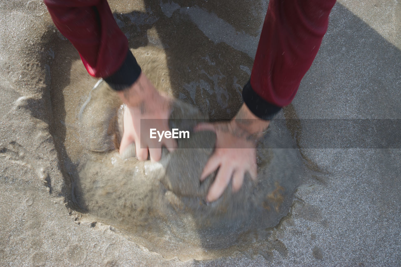 LOW SECTION OF PERSON AT BEACH