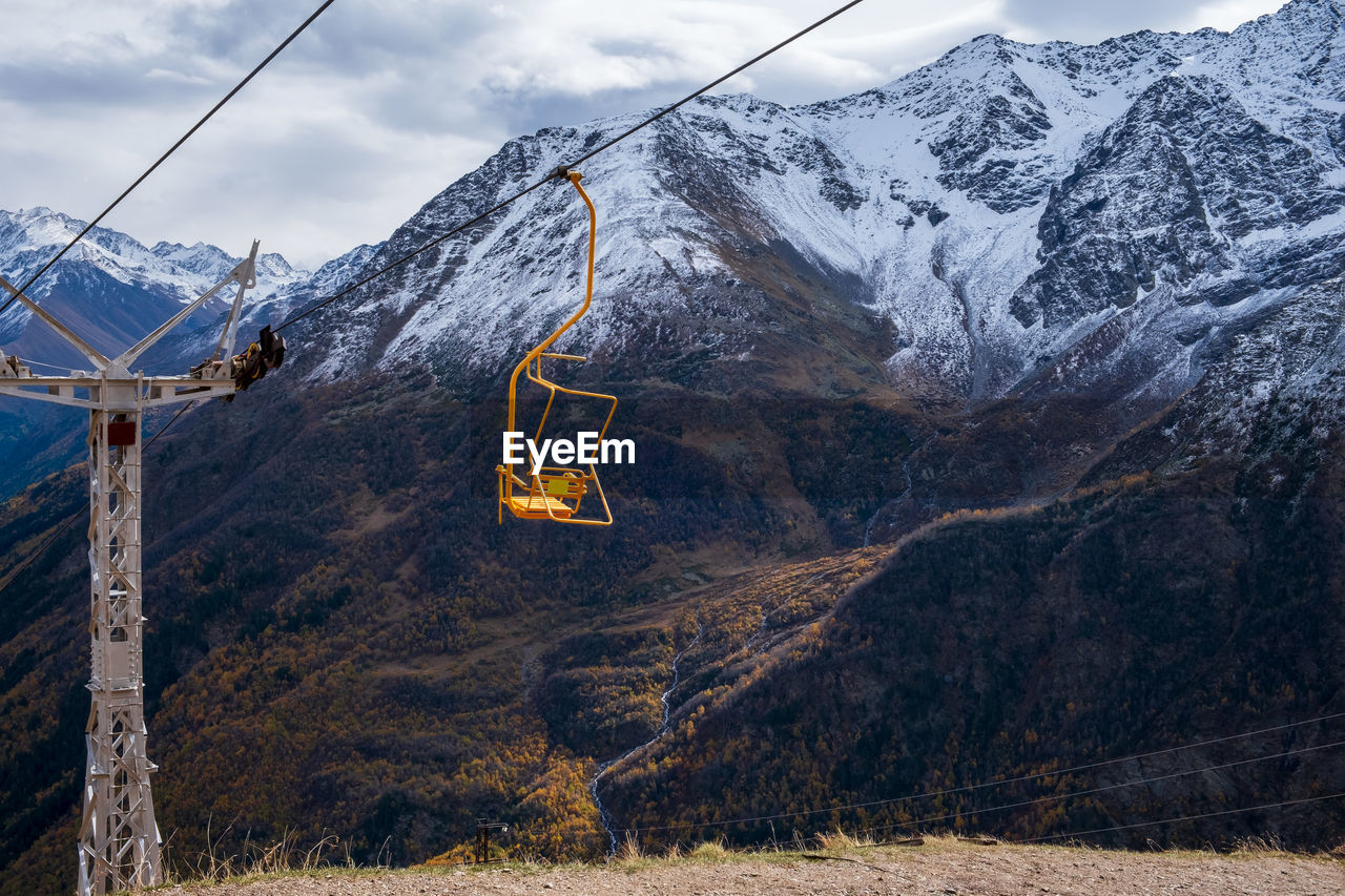 Mountain landscape with a moving chair of a single-seat cable car for hikers and climbers.