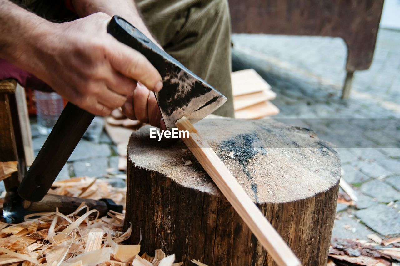 Close-up of man cutting wood