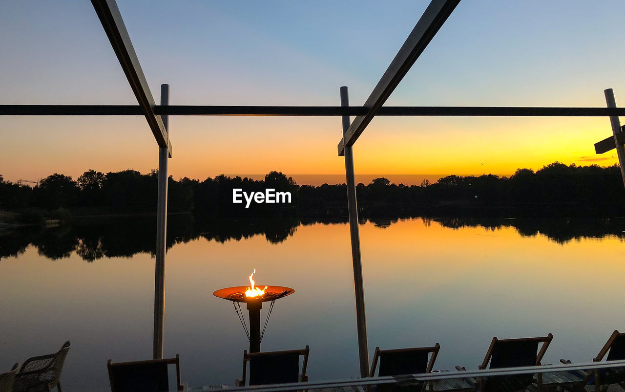 Scenic view of lake against sky at sunset
