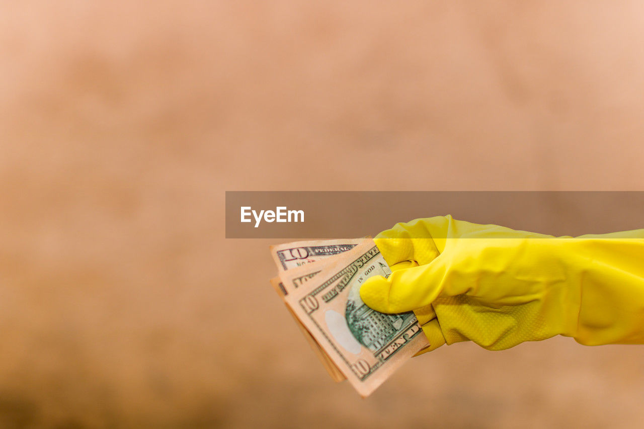 yellow, finance, hand, currency, close-up, business, paper currency, wealth, copy space, protective glove, holding, protection, business finance and industry, protective workwear, macro photography, savings, adult, one person, security, finance and economy, cleaning
