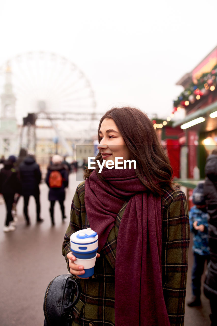 Pretty woman holding reusable coffee cup