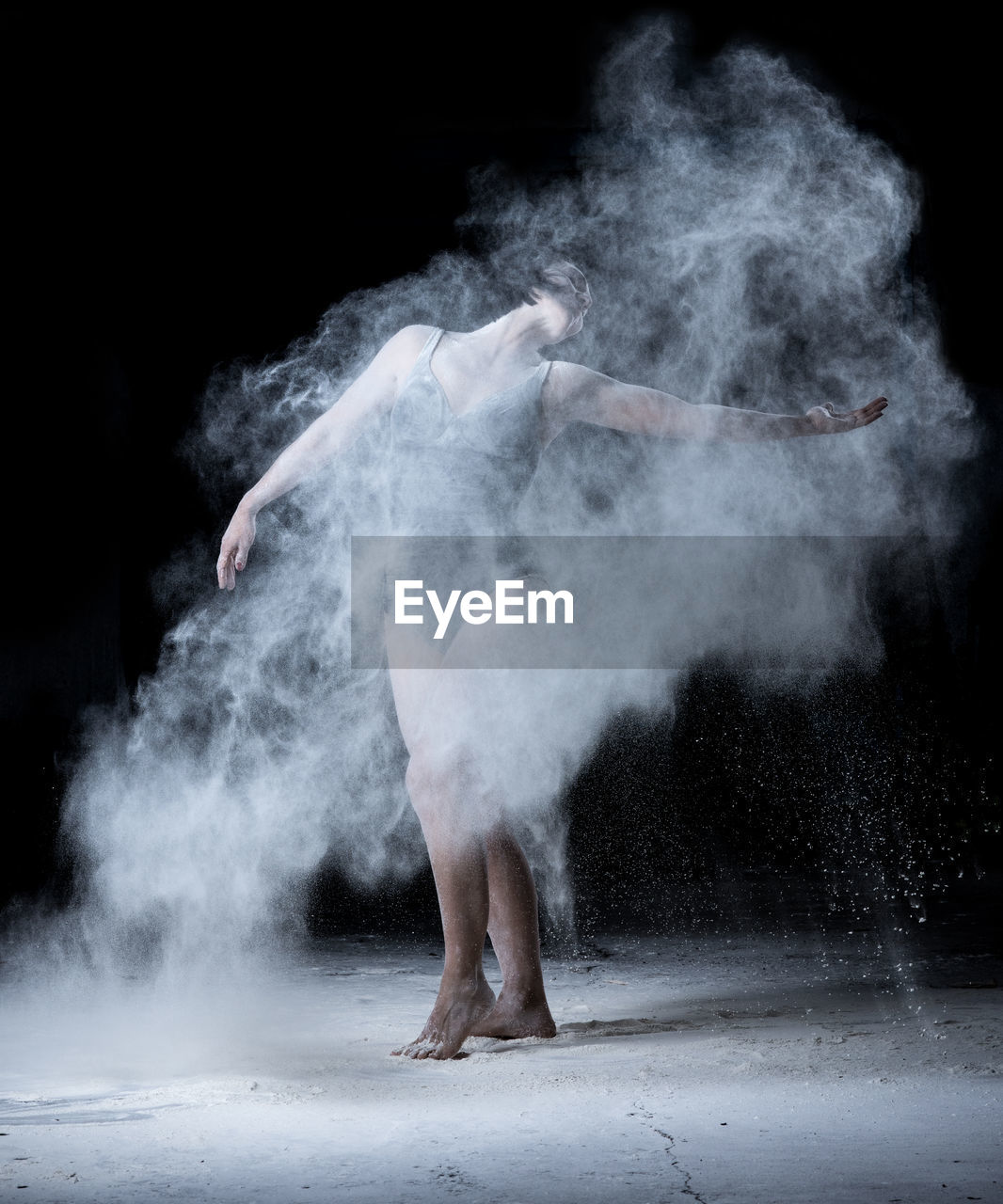 Full length of ballet dancer against black background