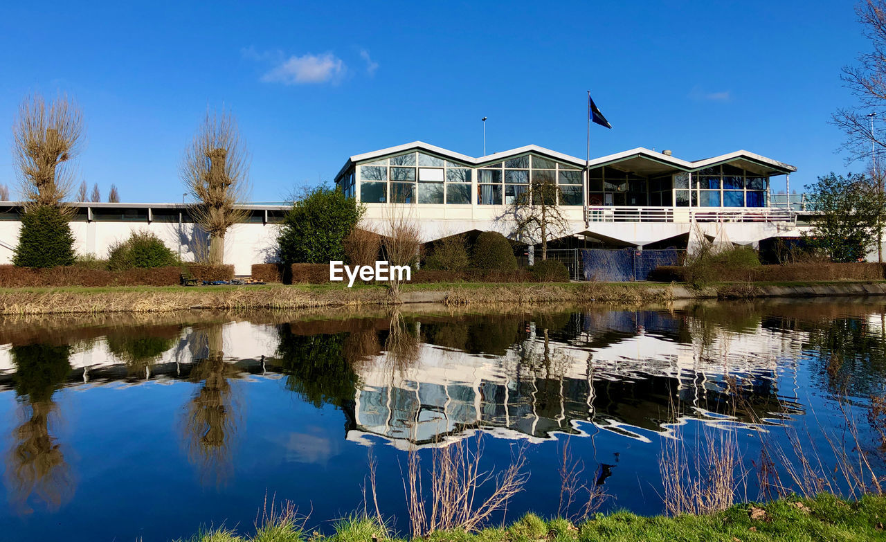 HOUSES BY LAKE AGAINST SKY