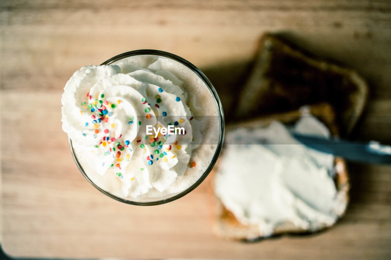 Close up of drink with whipped cream and sandwiches