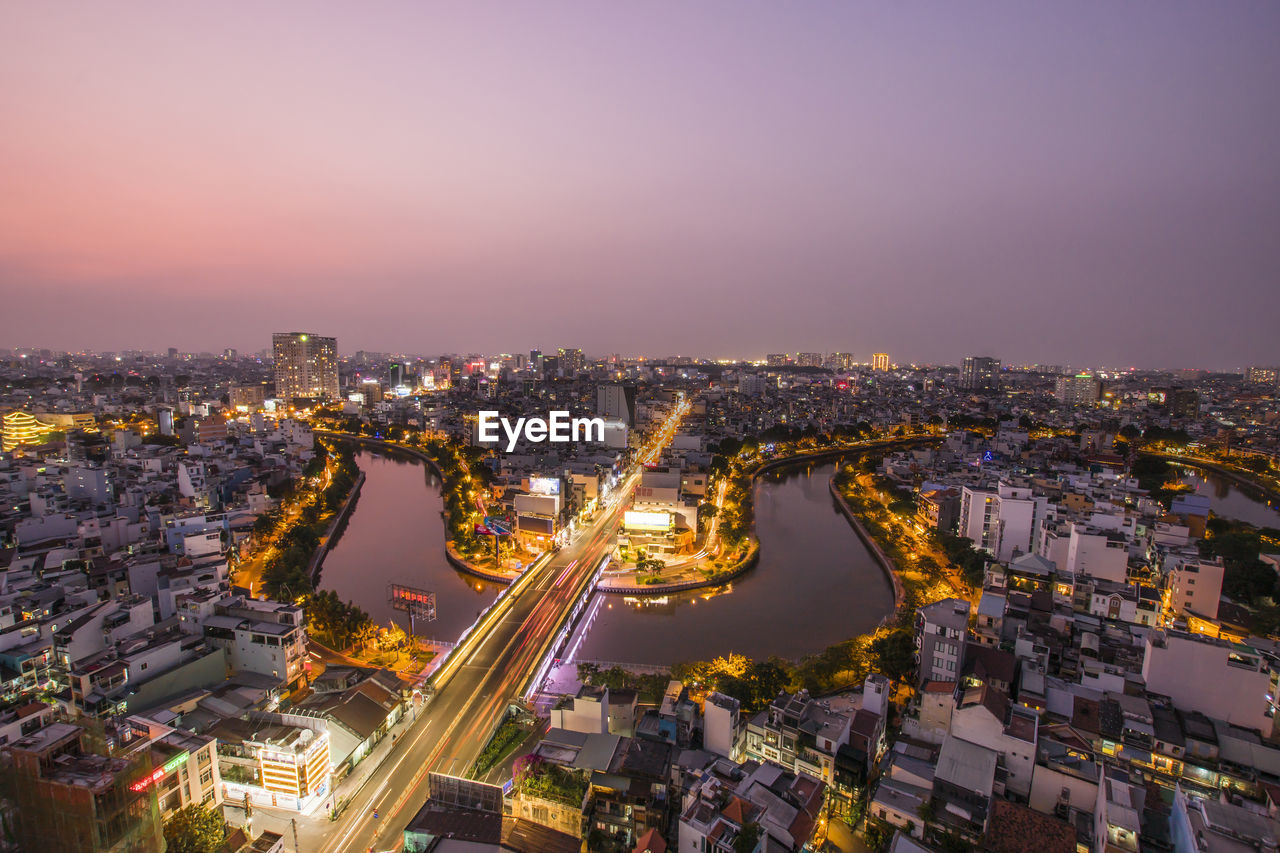 HIGH ANGLE VIEW OF ILLUMINATED CITY BUILDINGS AGAINST SKY